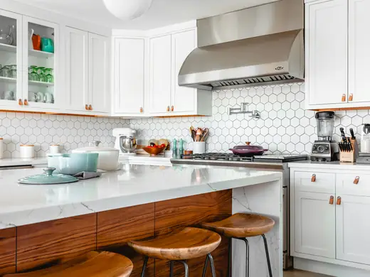 White kitchen with open shelving and a wood table